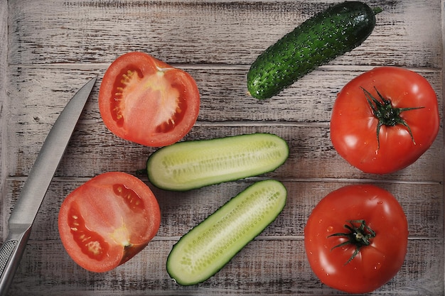 cucumbers and tomatoes on a wooden background - top view