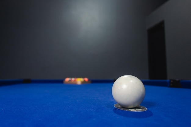 Cue ball klaar om de anderen te raken op de blauwe pooltafel in de bar.