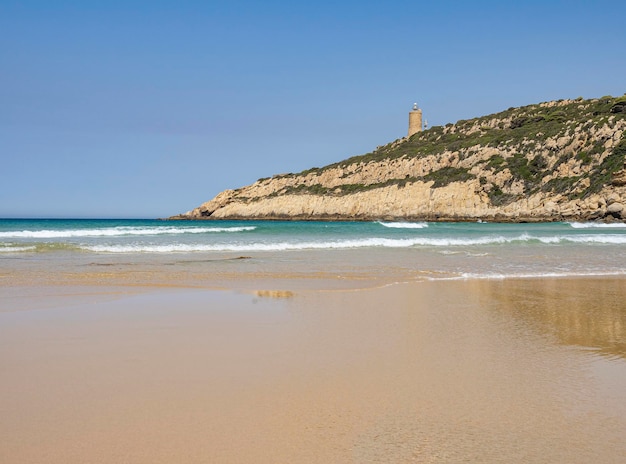 Cuelostrand in het strand van Spanje zonder mensenachtergrond een berg met een vuurtorenrust