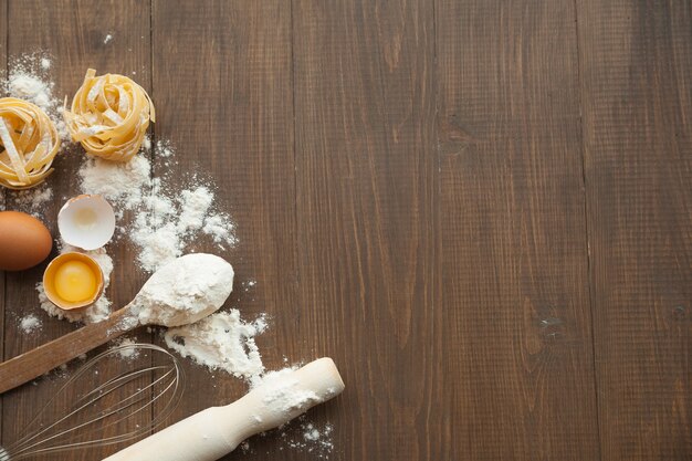 Photo cuisine composition with cracked eggs,kitchenware, flour. view from above