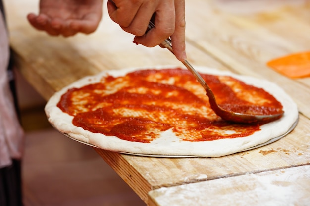 Culinaire chef-kok die tomatenpizza kookt