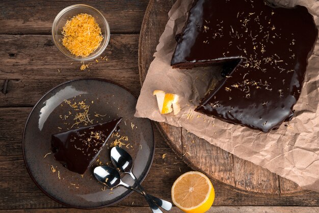 Culinary background with chocolate cake with lemon and zest on a wooden background.