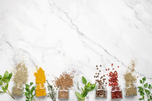 Culinary background with spices Cooking Fresh herbs and spices in jars on a gray stone background