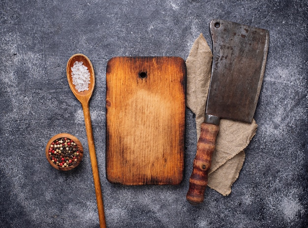 Culinary background with spices, cutting board and hatchet  