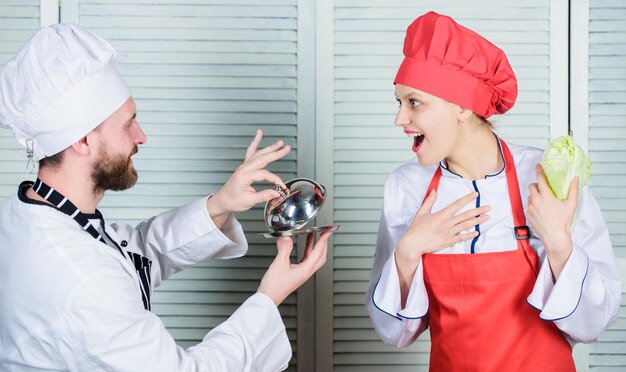 Foto famiglia culinaria donna e uomo barbuto che cucinano insieme cucino un pasto esclusivo unisciti a uno stile di vita gourmet proposta deliziosa uomo cuoco offre dessert o pasto sotto la cloche alla ragazza mangierai il mio pasto