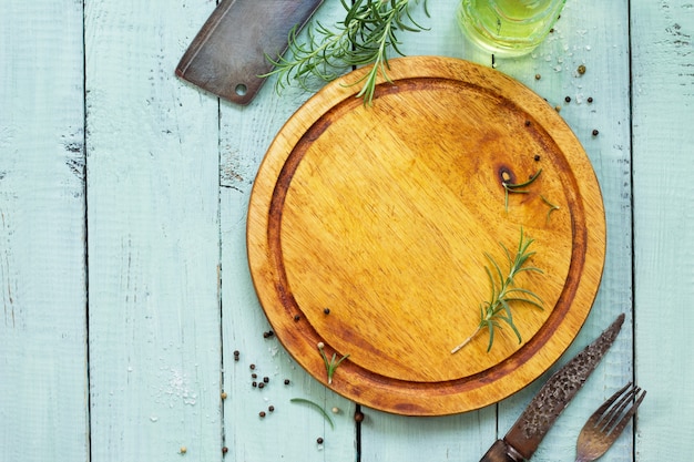 Culinary surface Cutting board various spices and rosemary on a wooden kitchen table Flat lay top view with copy space