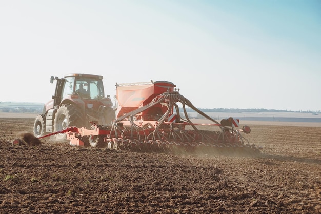 Cultivating tractor in the field. Farmer plowing the field.