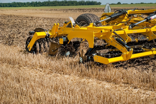 Photo cultivator at work, close up of a disc harrow on a field background