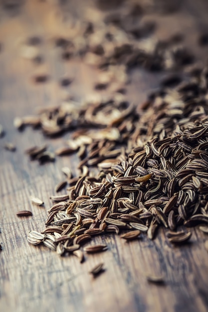 Cumin.Caraway seeds on wooden table. Cumin in vintage bronze bowl and spoon.