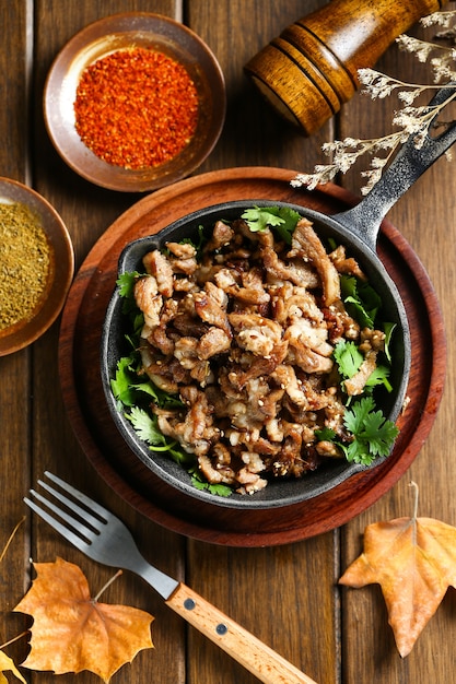 cumin fried lamb in pot on wooden table