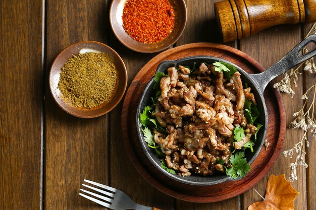 cumin fried lamb in pot on wooden table