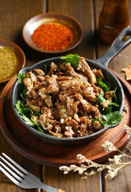 cumin fried lamb in pot on wooden table