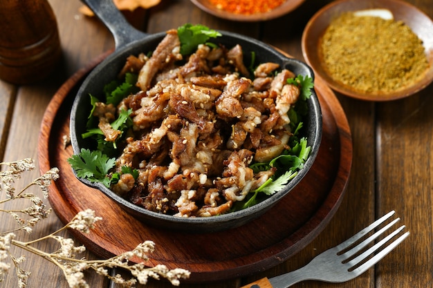 Photo cumin fried lamb in pot on wooden table