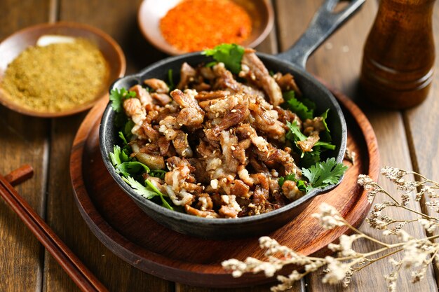 Photo cumin fried lamb in pot on wooden table