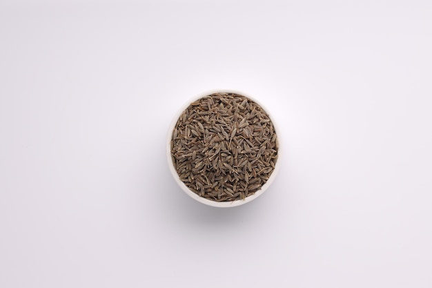 Cumin seed Indian spices arranged on a white bowl on a white background