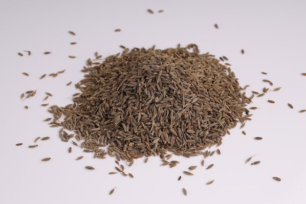 Cumin seed Indian spices arranged on a white textured background