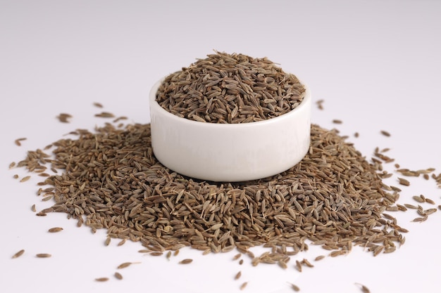 Cumin seed Indian spices arranged on a white textured background