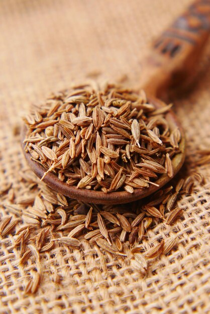 Cumin seeds on spoon on table  close up