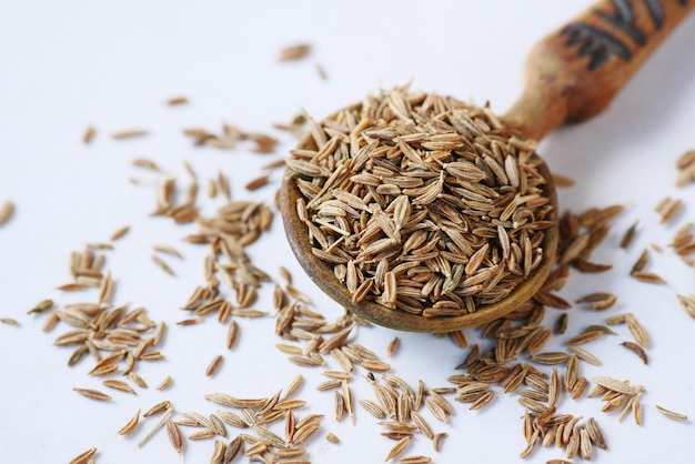 Photo cumin seeds on spoon on table  close up