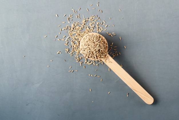 Cumin seeds on spoon on table top view