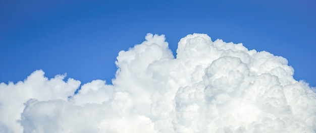 Cumulus clouds across blue sky background