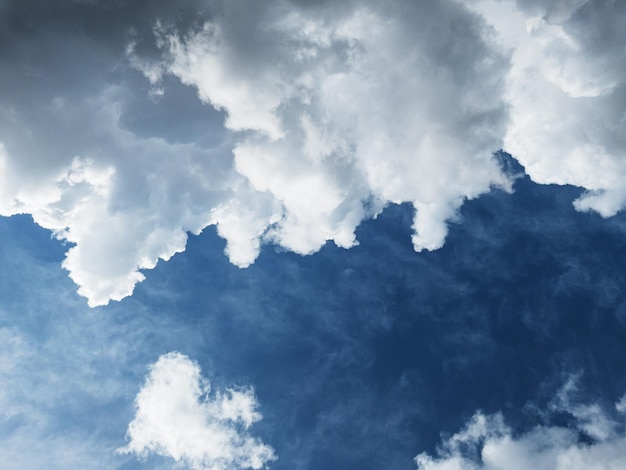 Cumulus clouds diagonally against a dark blue sky