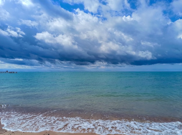 Cumulus clouds over the sea dramatic seascape waves on the shore kyrgyzstan lake issykkul