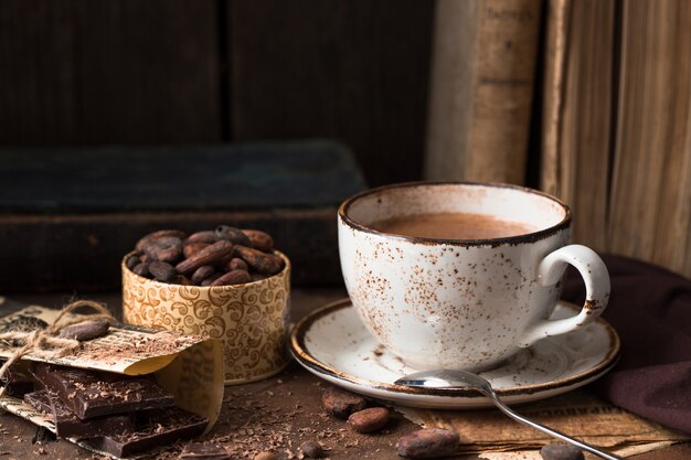 cup of aromatic cacao on old  table  with cacao beans
