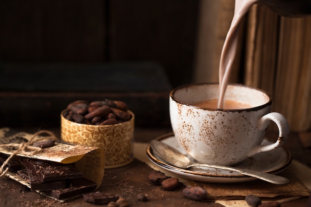 Cup of aromatic cacao on old  table  with cacao beans