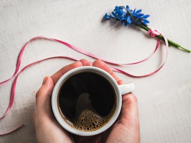 Cup of aromatic coffee and spring flowers