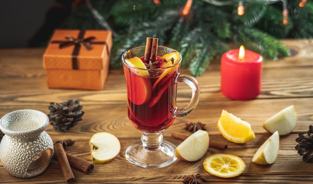 Cup of aromatic hot mulled wine on a wooden table