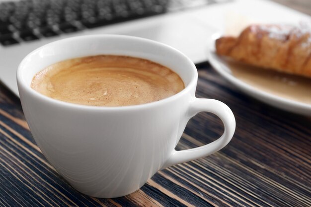 Cup of aromatic morning coffee on wooden table