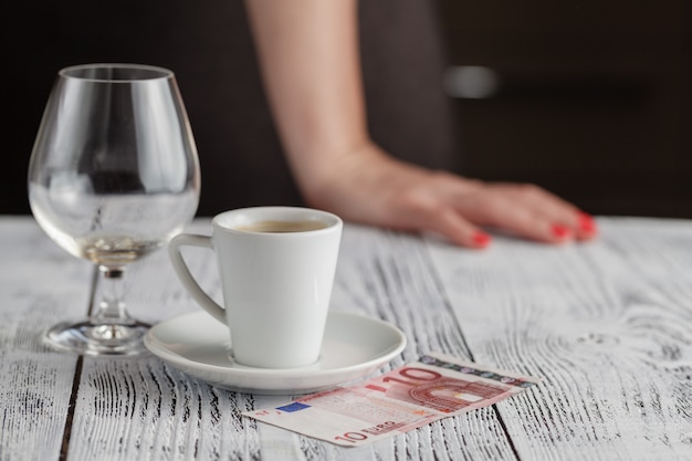 Cup of black coffee and euro banknotes