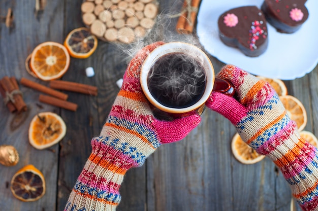 Cup of black coffee in his hands over the table