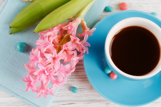 Cup of black coffee and pink flower