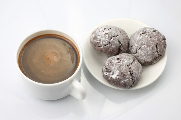 cup of black coffee with biscuits on white