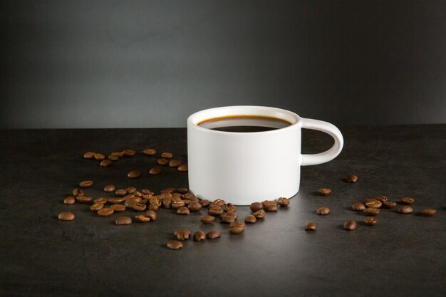 a cup of black coffee with coffee beans around