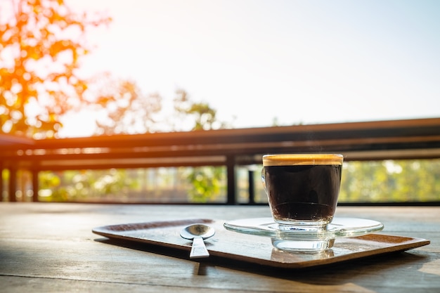 テーブルに泡のある黒いコーヒーのカップ。