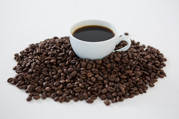 Cup of black coffee with roasted coffee beans