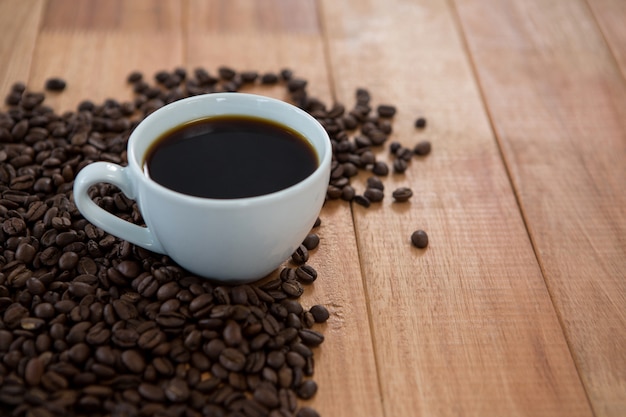 Cup of black coffee with roasted coffee beans