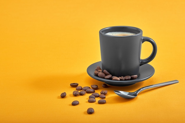 Cup of black coffee on a yellow