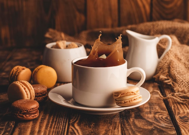 Cup of black offee milk sugar and macaroons on wooden background