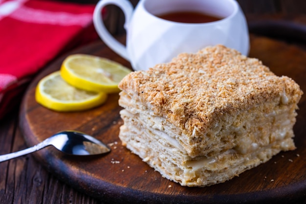 A cup of black tea and a plate with homemade bakery biscuit on a wooden table Closeup