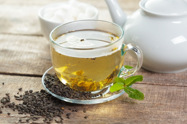 Photo cup of black tea with mint leaves on a wood