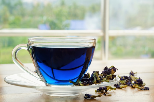 Cup of blue tea on wooden table