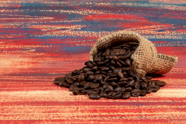 Cup of Brazilian roasted coffee in a bag falling in a rusty table