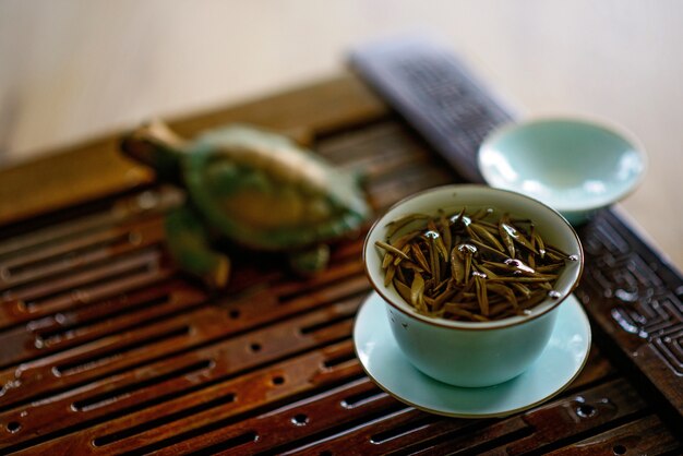 A cup of brewed Chinese white tea on a tea board. Tea ceremony.