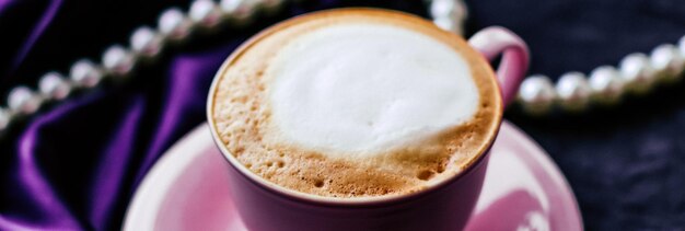 豪華なビンテージ ホリデー ブランドのパリのカフェでサテンと真珠のジュエリー背景有機コーヒーとラクトース フリー ミルクと朝食のカプチーノのカップ