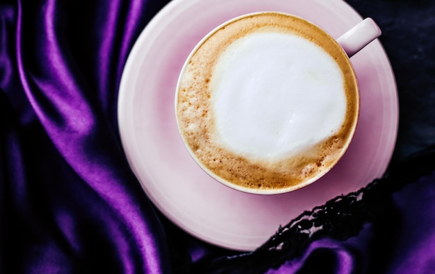 Photo cup of cappuccino for breakfast with satin and pearls jewellery background organic coffee with lactose free milk in parisian cafe for luxury vintage holiday brand