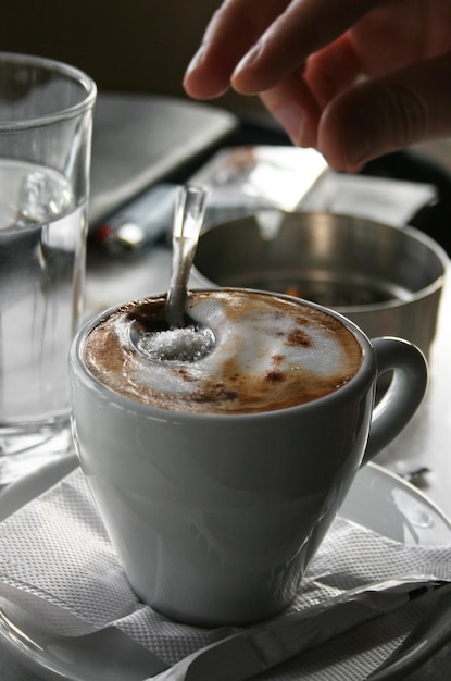 A cup of cappuccino coffee on the table in a cafe in Greece